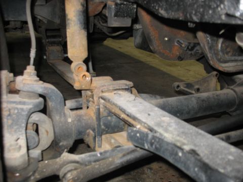 1995 Ford C-350 (Centurion Conversions) - This photo shows a close-up view of a vehicle's suspension system, focusing on the leaf springs and shock absorber.