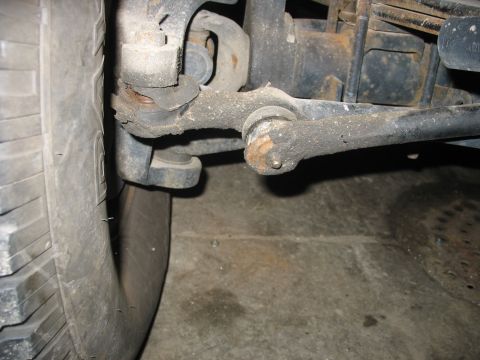 1995 Ford C-350 (Centurion Conversions) - Worn suspension components, including a ball joint and tie rod end, are visible near a tire.