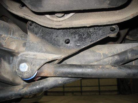 1995 Ford C-350 (Centurion Conversions) - A close-up view of a vehicle's suspension system, focusing on a bracket and linkage.