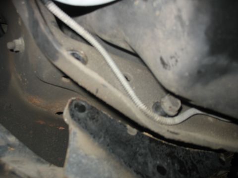 1995 Ford C-350 (Centurion Conversions) - Undercarriage view of a vehicle's suspension system, showing frame components and a wire conduit.