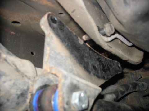 1995 Ford C-350 (Centurion Conversions) - A close-up view of a vehicle's suspension system, highlighting a black bracket and blue bushings.