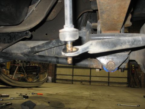 1995 Ford C-350 (Centurion Conversions) - Underside view of vehicle suspension parts, including a sway bar end link and leaf spring mount.