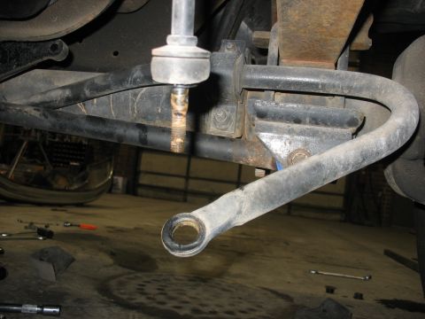 1995 Ford C-350 (Centurion Conversions) - Underside view of a vehicle's suspension system, with tools scattered on the floor.
