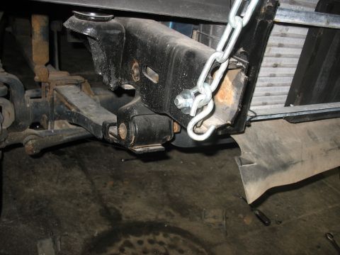 1995 Ford C-350 (Centurion Conversions) - Detail of a vehicle's suspension system, showing a chain secured to a metal bracket.