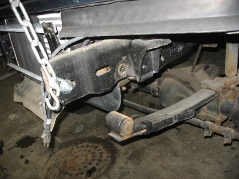 1995 Ford C-350 (Centurion Conversions) - Close-up view of truck suspension components, including leaf springs and a shock absorber.