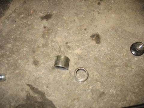 1995 Ford C-350 (Centurion Conversions) - Metal parts, possibly from a vehicle suspension, lie on a concrete surface.