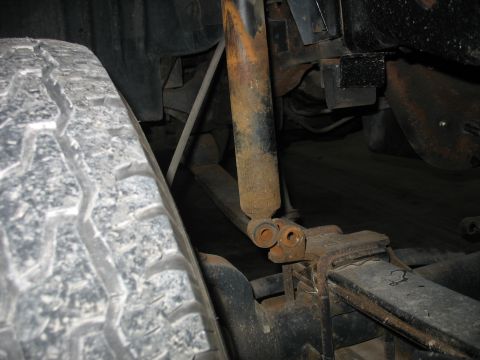1995 Ford C-350 (Centurion Conversions) - The rear suspension shows a worn shock absorber and leaf springs, indicating age and use.