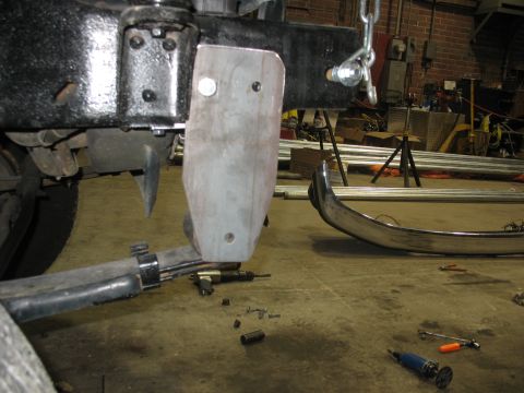 1995 Ford C-350 (Centurion Conversions) - A close-up view of a vehicle's frame and suspension components, with a metal plate bolted on.