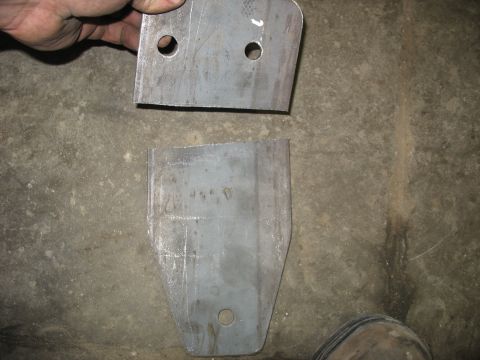 1995 Ford C-350 (Centurion Conversions) - Two metal brackets are shown, one held by a hand against a concrete background.