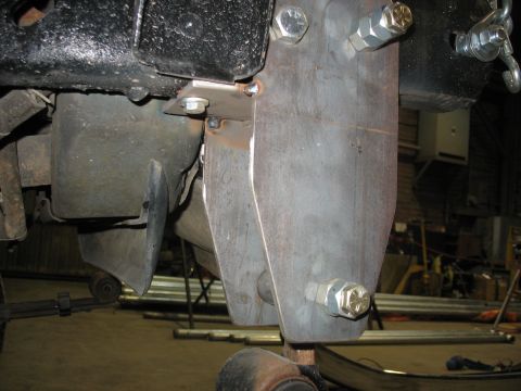 1995 Ford C-350 (Centurion Conversions) - A custom-fabricated metal bracket is attached to the underside of a vehicle, likely for suspension modification.