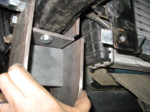 1995 Ford C-350 (Centurion Conversions) - Close-up view of a custom suspension bracket installation, showing its attachment points near the vehicle's radiator.