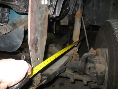 1995 Ford C-350 (Centurion Conversions) - A yellow tape measure is used to check the clearance on a modified vehicle suspension component.