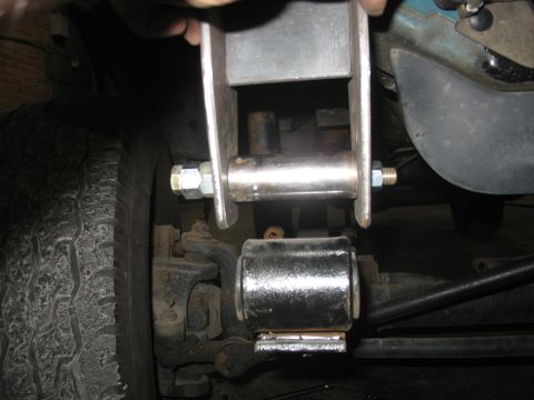1995 Ford C-350 (Centurion Conversions) - A person's hand is visible, holding a metal bracket near a vehicle's suspension system.