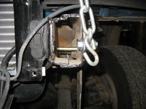 1995 Ford C-350 (Centurion Conversions) - The tow hitch receiver on the vehicle's frame is shown with a chain connected to it.