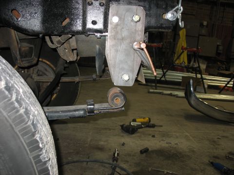 1995 Ford C-350 (Centurion Conversions) - Close-up of a custom suspension bracket installation on a vehicle frame, showing leaf spring and hardware.