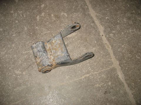 1995 Ford C-350 (Centurion Conversions) - This is a single leaf spring shackle, likely from a truck, resting on a concrete surface.