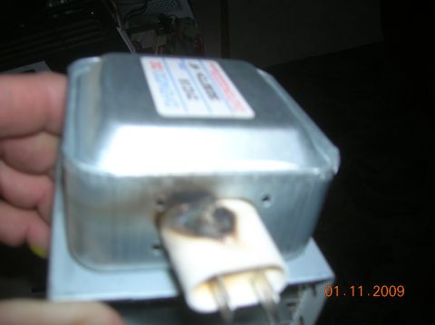1985 Ford Bronco - A close-up view of a burned microwave magnetron, showing damage to the output waveguide and a label with text and a date stamp of 01.11.200…