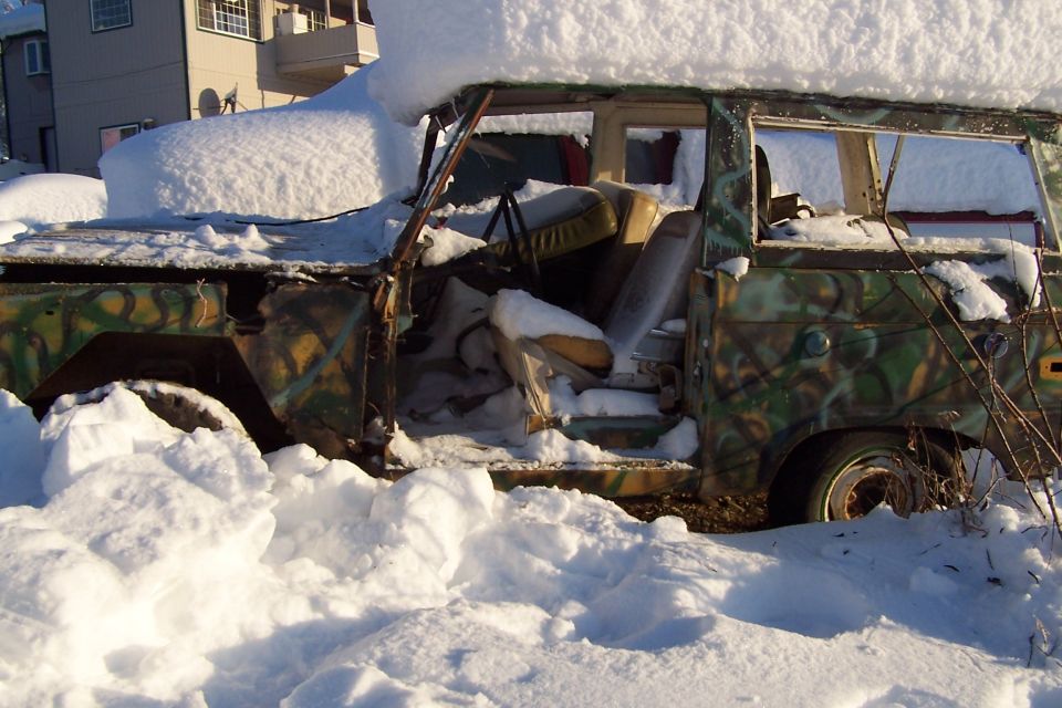 Snow-covered camouflage 1987 Ford Bronco II with doors open.