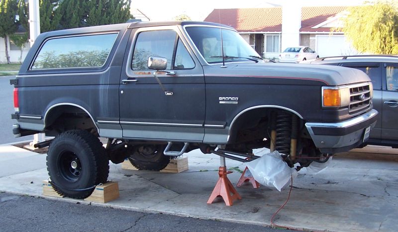 1990 Ford Bronco lifted on jack stands with front end disassembled