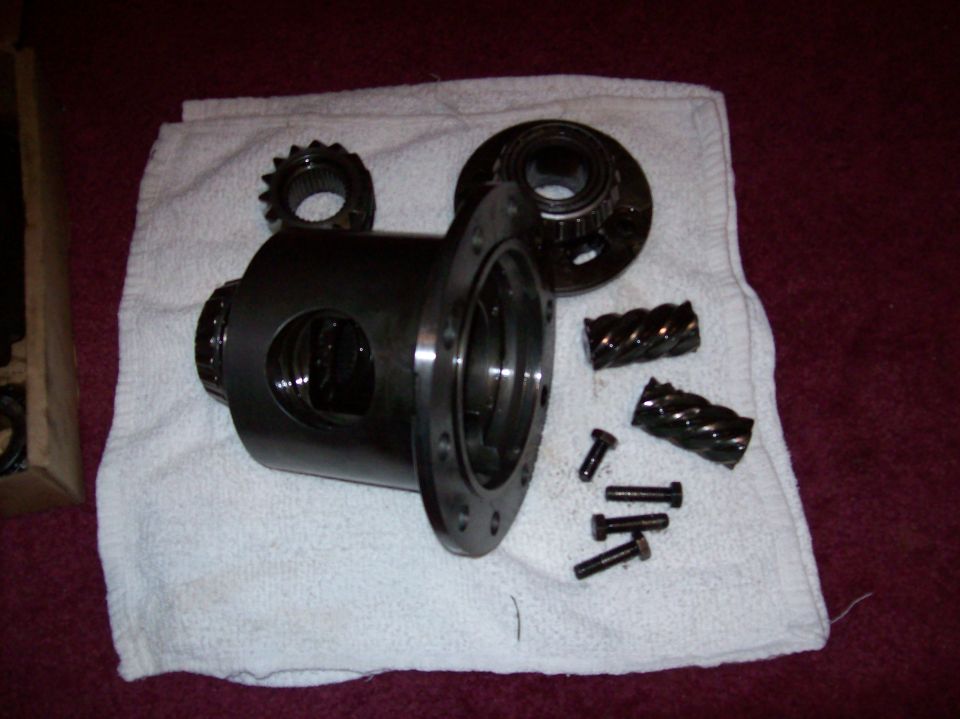 Differential parts including housing, gears, and bolts on a white towel.