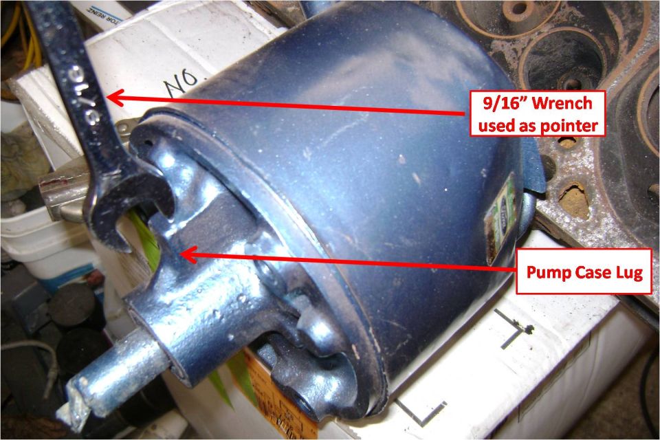 Blue power steering pump with wrench pointing to pump case lug