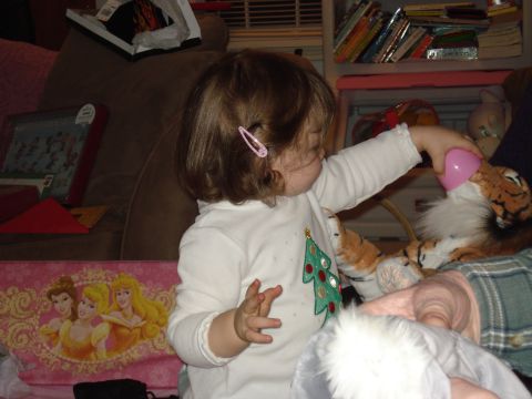 2000 Ford Crown Victoria - A young child is playing with a stuffed tiger and a pink plastic egg, sitting on a couch with a pink blanket featuring princesses in the fo…