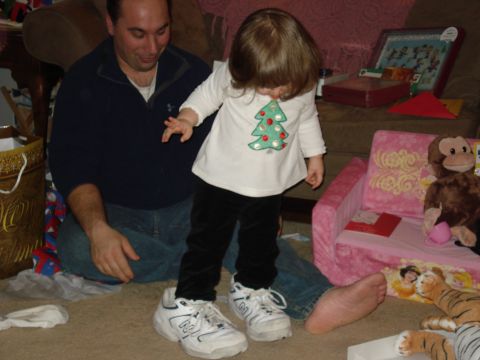 2000 Ford Crown Victoria - A man and a young child are sitting on the floor in a living room, surrounded by toys and gifts. The child is wearing a shirt with a Christ…