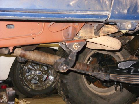 1988 Ford Bronco - Close-up view of the undercarriage of a blue vehicle, showing suspension components and exhaust system.