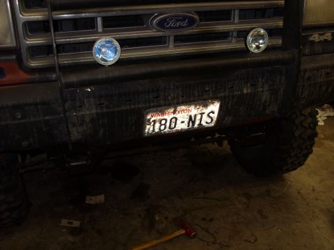 1988 Ford Bronco - Close-up of a Ford truck's front bumper and grille, a Washington state license plate.