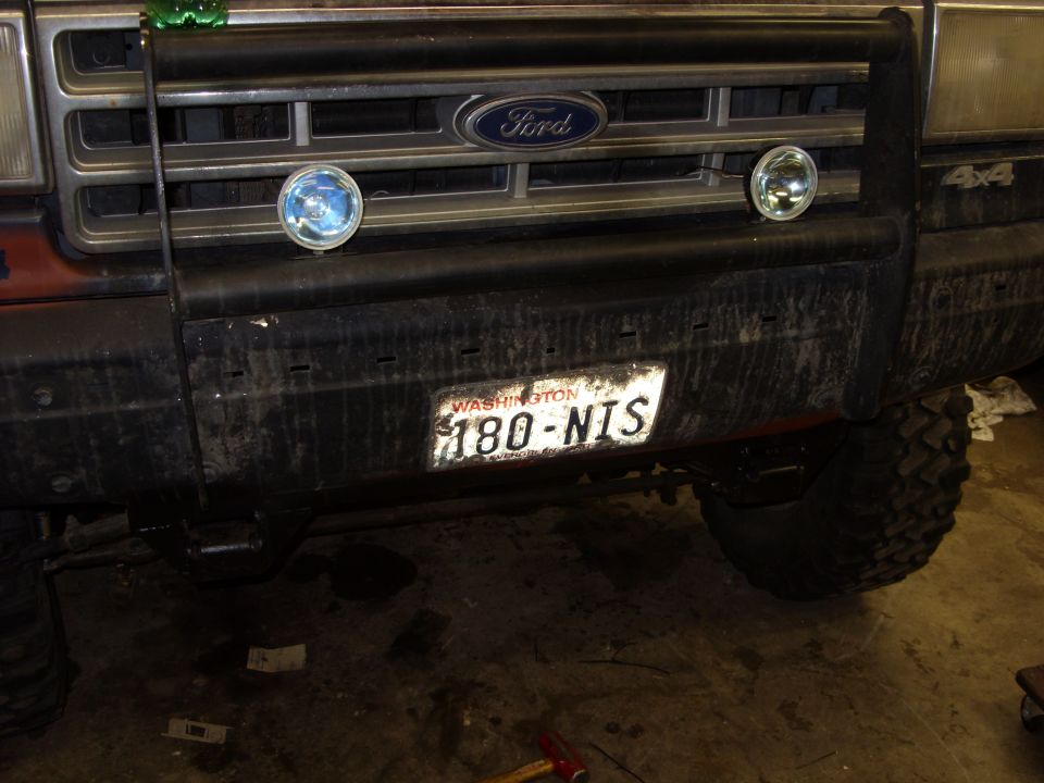Front grille and bumper of a 1987 Ford Bronco with a bull bar and auxiliary lights