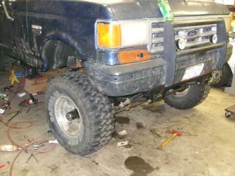 1988 Ford Bronco - Front view of a blue Ford Bronco, possibly from the late 1980s, in a workshop setting.