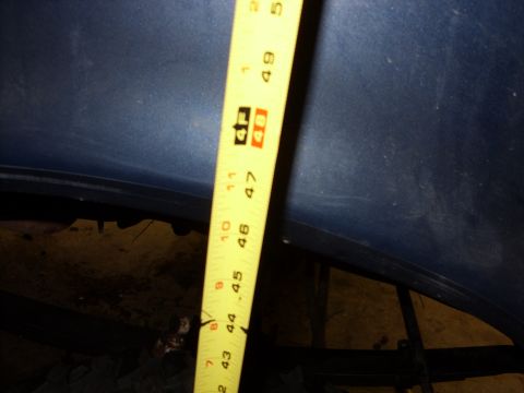 1988 Ford Bronco - A blue car hood is measured with a yellow tape measure.