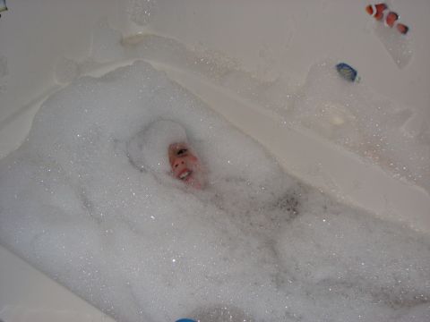 1991 Ford Bronco - A child enjoys a bubbly bath, with a clownfish toy visible near the surface.