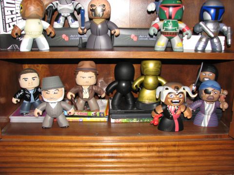 1991 Ford Bronco - A collection of pop culture figures displayed on wooden shelves.