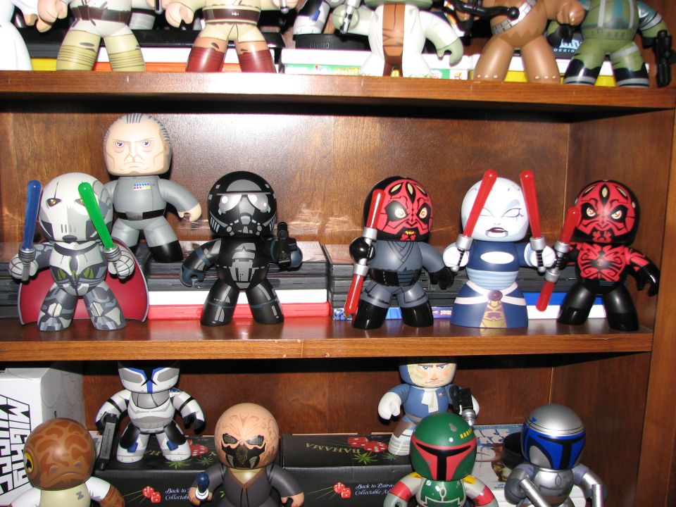 Star Wars figures on a wooden shelf, including Darth Maul and Boba Fett
