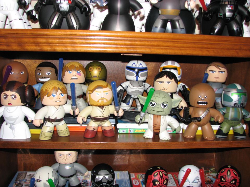 Collection of Star Wars character figures displayed on wooden shelves