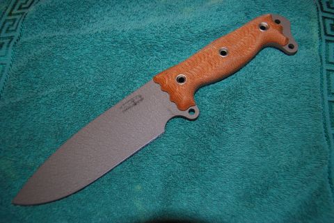 1991 Ford Bronco - Knife with a textured brown handle and gray blade on a teal towel.