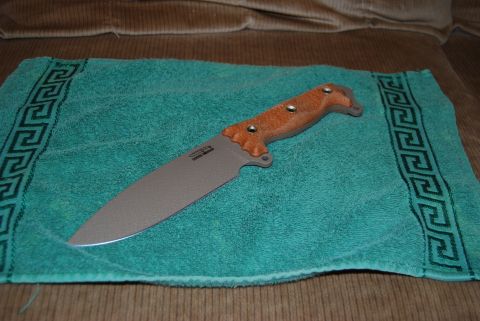 1991 Ford Bronco - A knife with a tan handle and a gray blade is placed on a teal towel with a decorative border.