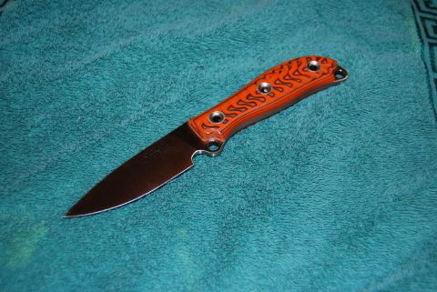 1991 Ford Bronco - A knife with an orange handle and a steel blade is placed on a teal towel.