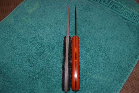 1991 Ford Bronco - Comparison of two knives, one with a black handle and the other with an orange handle, displayed on a teal towel.