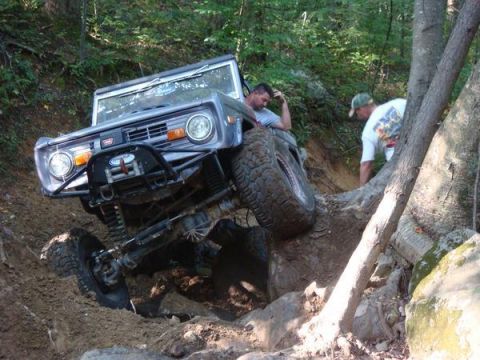 1978 Ford Bronco - This vehicle is tackling a challenging off-road trail with significant elevation changes and obstacles.