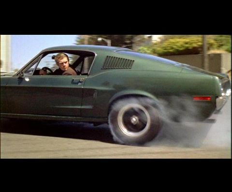 1988 Mercury Grand Marquis - A driver performs a burnout in a green 1967 Ford Mustang Fastback on a paved road.