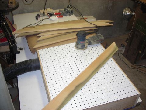 1995 Ford Bronco - A collection of woodworking tools, including a sander and clamps, are arranged on a workbench with various pieces of lumber.