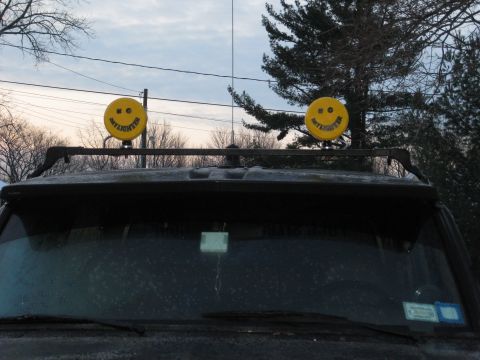1995 Ford Bronco - Two yellow "Daylighter" lights with smiley faces are mounted on a roof rack.