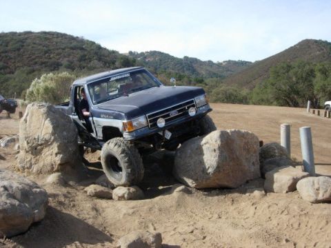 1989 Ford Bronco - This modified 1987 Ford F-150 navigates a challenging rocky terrain, its off-road capabilities.