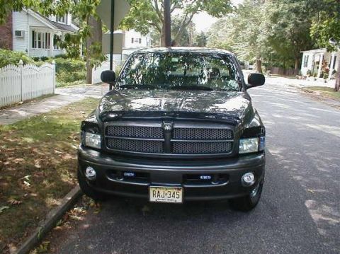 1989 Ford Bronco - Front view of a black Dodge Ram pickup truck parked on a residential street. The license plate reads RAJ-345.