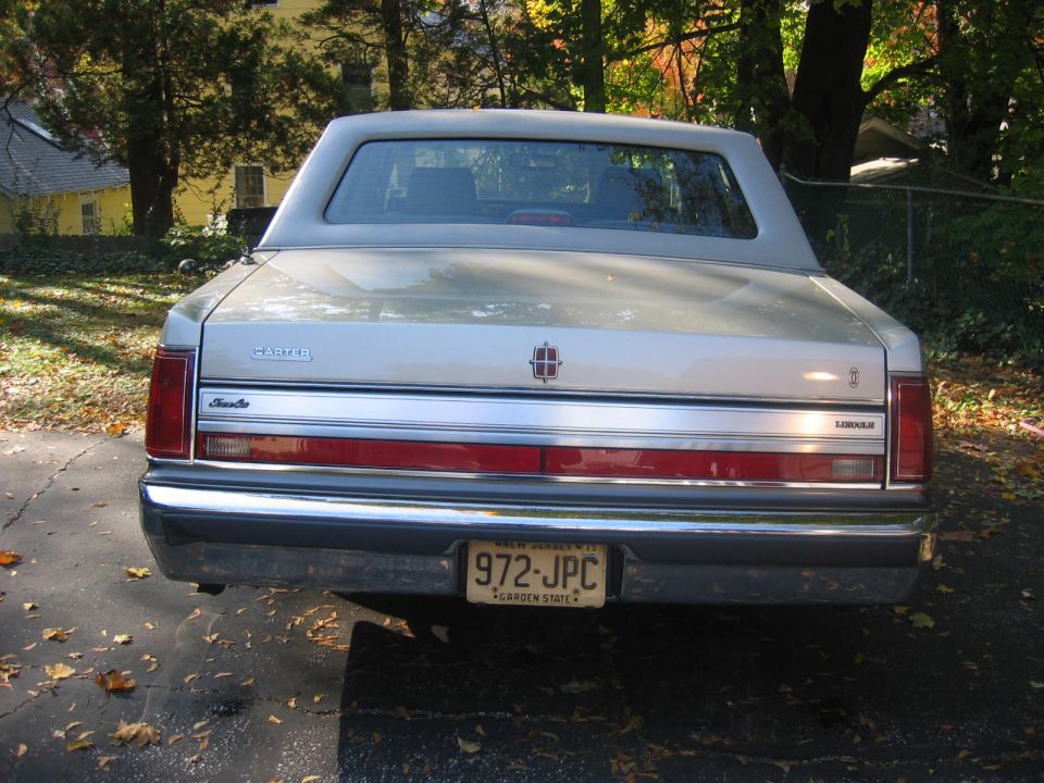 Rear view of a silver 1980s Lincoln Town Car with a New Jersey license plate