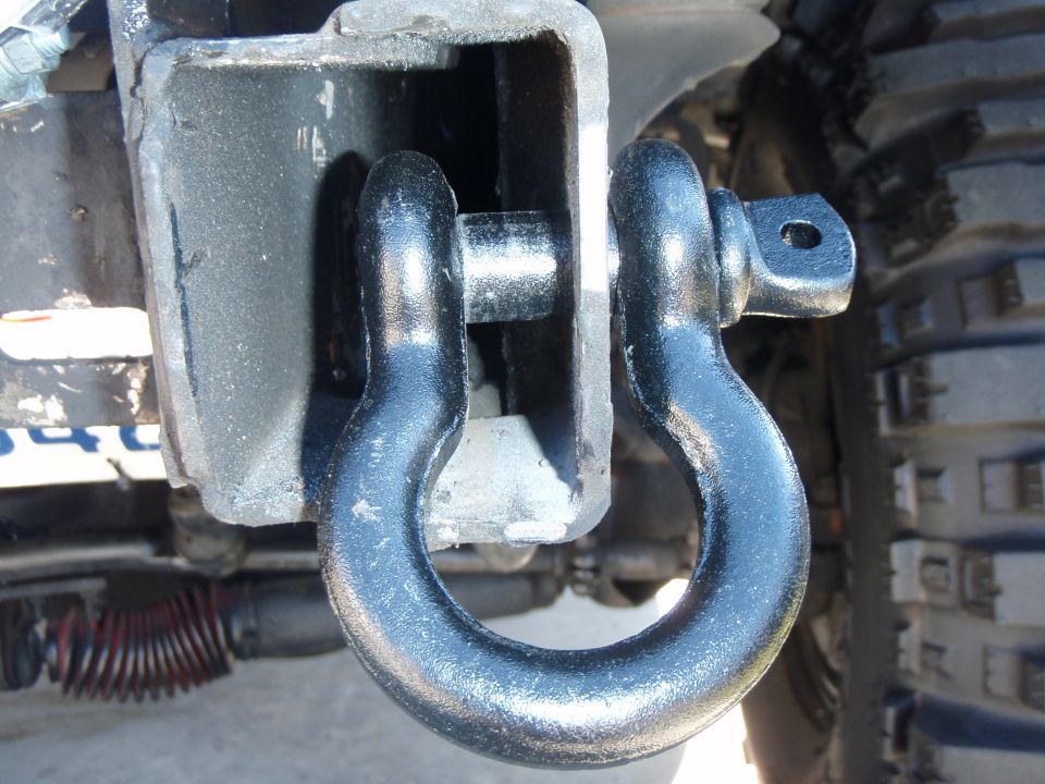 Black D-ring shackle attached to a receiver hitch on a vehicle.