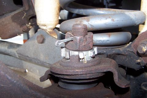 1990 Ford Bronco - Ball joint assembly with castle nut and cotter pin, part of a vehicle's suspension system.