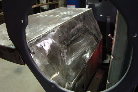 1948 Jeep Wrangler - A close-up view of a metal body panel undergoing repair, showing numerous welds and grinding marks.